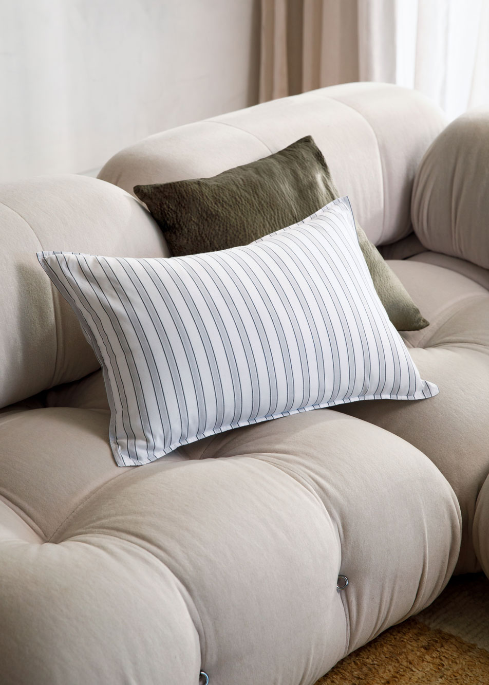 Two cushions stacked on a beige lounge.